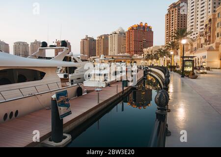 Barche ormeggiate presso un porto turistico nel Pearl-Qatar, un'isola residenziale artificiale a Doha, Qatar Foto Stock