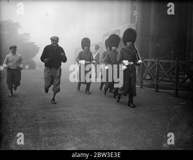 Il pugile tedesco Welter Neusel si allena per Jack Petersen match . Passando le guardie del Palazzo di Windsor mentre si è in una corsa di allenamento. 10 gennaio 1935 Foto Stock