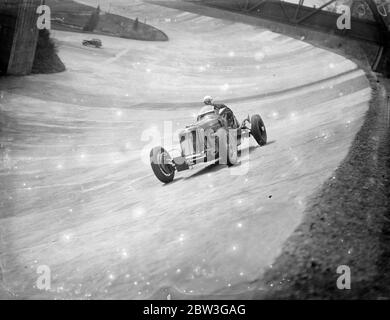 I conducenti si esercitano a Brooklands per l'incontro del lunedì di Pasqua. I piloti si sono allenati in pista a Brooklands per l'incontro del lunedì di Pasqua del Brooklands Automobile Racing Club . Foto spettacoli , UN Powys Lybbe che velocizza la pista di Brooklands nella sua Alfa Romeo durante la pratica . 11 aprile 1936 Foto Stock