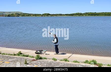 Eastbourne UK 29 maggio 2020 - UN pescatore di mosca getta fuori la sua linea al serbatoio di Arlington vicino Eastbourne in Sussex in una giornata calda di sole durante la crisi pandemica di Coronavirus COVID-19 . Credit: Simon Dack / Alamy Live News Foto Stock