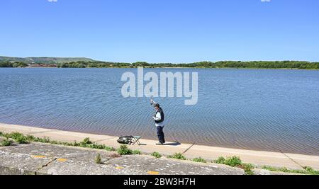 Eastbourne UK 29 maggio 2020 - UN pescatore di mosca getta fuori la sua linea al serbatoio di Arlington vicino Eastbourne in Sussex in una giornata calda di sole durante la crisi pandemica di Coronavirus COVID-19 . Credit: Simon Dack / Alamy Live News Foto Stock