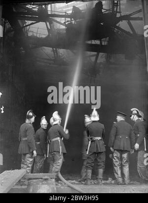 Il fuoco infuria ai nuovi studi cinematografici di Denham , Buckinghamshire . Vigili del fuoco al lavoro all'interno dell'edificio bruciato. 17 marzo 1935 Foto Stock