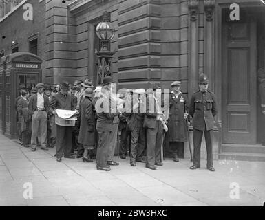 Grandi folle a Bow Street quando McMahon appare - ma la polizia admited solo 20 . Anche se una lunga coda aspettava dalla mattina presto , la polizia ha ammesso solo 20 persone alla corte di polizia di Bow Street quando George Andrew McMahon [ alias del truffatore irlandese Jerome Bannigan ] , l'uomo che è stato arrestato su Constitution Hill quando il re stava ritornando da Hyde Park , comparve davanti al magistrato . Spettacoli fotografici : la grande folla fuori Bow Street Police Court . 24 Jul 1936 Foto Stock