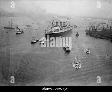 La ' RMS Queen Mary' salpa da Southampton in un viaggio da nubile. Allietato da un quarto di milione di persone che riempiono ogni pollice disponibile dei banchine . La Regina Mary, 80 anni, 000 e' orgogliosa della British Merchant Navy, salpò da Southampton in un suo primo viaggio in America. Era ' vestita su tutti ' con bandiere e centinaia di barche impavidite intorno a lei mentre si allontanava . Spettacoli fotografici , una vista aerea della 'RMS Queen Mary', lasciando i bacini di Southampton . 27 maggio 1936 Foto Stock