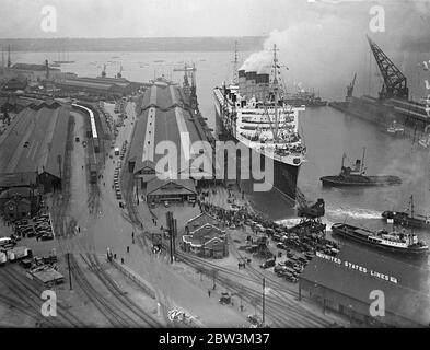 La ' RMS Queen Mary' salpa da Southampton in un viaggio da nubile. Allietato da un quarto di milione di persone che riempiono ogni pollice disponibile dei banchine . La Regina Mary, 80 anni, 000 e' orgogliosa della British Merchant Navy, salpò da Southampton in un suo primo viaggio in America. Era ' vestita su tutti ' con bandiere e centinaia di barche impavidite intorno a lei mentre si allontanava . Spettacoli fotografici , una vista aerea della 'RMS Queen Mary', lasciando i bacini di Southampton . 27 maggio 1936 Foto Stock