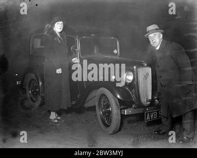 L'uomo della città dà l'automobile al Vicario di Coster di St Mary Maddalene , Old Kent Road . Il Rev A Barker che avvia il motore della sua auto . Anche nella foto è la signora Barker . 7 dicembre 1935 Foto Stock