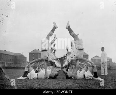 Gli uomini RAF provano i jerks fisici per il Royal Tournament . Il partito di addestramento fisico che la Royal Air Force sta contribuendo al Torneo reale di Olympia ha provato i loro ' tiri fisici ' al deposito della Royal Air Force, Uxbridge . Foto mostra , un esercizio di bilanciamento . 27 aprile 1936 Foto Stock