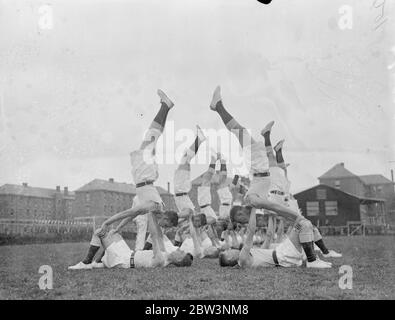 Gli uomini RAF provano i jerks fisici per il Royal Tournament . Il partito di addestramento fisico che la Royal Air Force sta contribuendo al Torneo reale di Olympia ha provato i loro ' tiri fisici ' al deposito della Royal Air Force, Uxbridge . Foto mostra , un esercizio di bilanciamento . 27 aprile 1936 Foto Stock