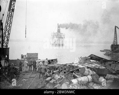 Crane da l'ultima vista di 40 , 000 tonnellate gigante guidato a terra a Bo' Ness una volta una delle navi più prouditi che navigava i sette mari , il 40 , 000 tonnellate di transatlantico americano di lusso Columbia fu fatto correre sotto il suo potere sulla costa scozzese a Bo' Ness per essere rotto . La Columbia è lunga 700 piedi. Foto spettacoli , visitatori che guardano la Columbia dalla gru sopra il ponte . 23 maggio 1936 Foto Stock