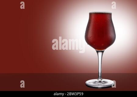 Birra di birra alla birra rossa in tulipano isolato su sfondo rubino Foto Stock