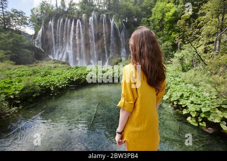 Donna che gode di vista delle cascate e dei laghi nel Parco Nazionale di Plitvice, Croazia Foto Stock