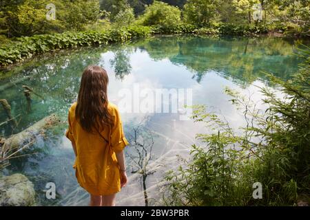 Donna che gode di vista delle cascate e dei laghi nel Parco Nazionale di Plitvice, Croazia Foto Stock