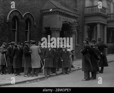 Gli sciatori ciechi attraversano Londra per inviare la deputazione alla sede dell' associazione. Più di 40 ciechi e parzialmente ciechi con armi collegate e bastoni bianchi che battono sulla strada per guidarli attraverso le strade di Londra fino alla sede della London Association for the Blind a Warwick Street, S W, Quando il sig. G. Haynes, segretario responsabile DELL' associazione, riceveva un mandato di cinque persone. Gli uomini sono impiegati come paniere ai laboratori dell'Associazione a Peckham Road , S e , ma hanno cessato il lavoro una settimana fa come protesta contro un suggerimento che alcuni di loro hanno guazzato Foto Stock