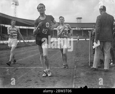 La Lettonia stabilisce il record del nuovo mondo per la camminata di miglio alla Police Sports P. Bernard di Lettonia ha stabilito un nuovo record mondiale di 6 min 21 1/5 sec . per la passeggiata di miglio al City of London Police Athletic Club sport annuali alla White City , Londra . Spettacoli fotografici : P . Bernardo di Lettonia (N. 2) sorpasso A . R . Cooper di Woodford Green A . A . che ha tentato anche di abbassare il record . 25 Jul 1936 Foto Stock