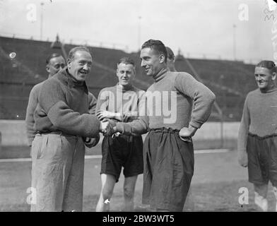 Sam Weaver si unisce al nuovo team dopo il trasferimento a Chelsea da Newcastle . Pioneer of the long' throw in' può lanciare la palla da touchline a goalpost , Sam Weaver , il Newcastle United e l'Inghilterra ha lasciato il mezzo di ritorno che è stato trasferito a Chelsea , si è Unito alla sua nuova squadra al Stamford Bridge , Londra , Ground . Weaver capitanò Newcastle la scorsa stagione , facendo 31 apparizioni di campionato . Nel 1932 fu chiuso contro la Scozia e nel 1933 contro la Scozia e l'Irlanda. Foto mostra , Sam Weaver ( a destra ) scuotendo le mani con Tommy Law , il Chelsea indietro , come è stato ricevuto dai membri della sua nuova squadra A. Foto Stock