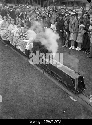 Incoronare la regina floreale a Southern ferrovia fiori show . L'incoronazione di Miss Violet e Larcomb come Floral Queen fu uno degli eventi dell'ottava mostra annuale Flower , Fruit and Vegtable delle sezioni Southern Railway e Eastern and Central ( London Area ) che si è svolta presso il campo sportivo , Plow Lane , Waddon . Foto spettacoli , Miss Violet e Larcomb seduta su un treno modello . . 19 agosto 1936 19 agosto 1936 Foto Stock