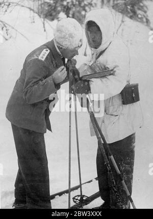 Principe della corona alle manovre dell'esercito svedese in Lapponia . Il principe ereditario Gustav Adolf sta assistendo alle manovre dell'esercito svedese che si svolgono attualmente nelle semoventi condizioni invernali della Lapponia . L'intera forza di fanteria è dotata di sci e la maggior parte dell'artiglieria con slitte . I furs sono l'uniforme predominante . Foto spettacoli , Principe ereditario Gustav Adolf ( a sinistra ) studiando una mappa alle manovre di Boden , lapponia . 11 marzo 1937 Foto Stock