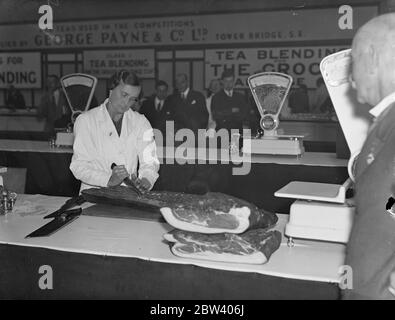 Donna cerca campionati di affettatrice di pancetta alla mostra del drocer . Il campione britannico di affettatrice di bacon uscirà dalla gara di affettatura di bacon alla mostra di negozio alimentare , Royal Agricultural Hall , Islington . Una donna , Miss e M Price di Gloucester è uno degli aspiranti . Il vincitore lo scorso anno è stata la signorina M L Aldou di Stowmarket . Foto spettacoli , Miss e M Prezzo di Gloucester circa per iniziare a lavorare sul lato della pancetta in concorso . 21 settembre 1936 Foto Stock