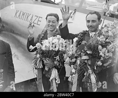 Gli aerei giapponesi atterrano a Croydon dopo voli record di 10,000 miglia. Dopo aver infranto tutti i record volando le 10,000 miglia da Tokyo a Londra in ben meno di 100 ore, gli airmen giapponesi Masaaki Iinuma e Kenji Tsukakoshi, sbarcati a Croydon nel loro aereo Divino Vento [Mitsubishi Ki-15 Karigane Aircraft, name: Kamikaze, registrazione J-BAI]. I volantini hanno portato i saluti di Coronazione dal Giappone. Foto mostra: Stanchi ma trionfanti, i piloti Masaaki Iinuma (a sinistra) e Kenji Tsukakoshi e il loro aereo: Vento divino [Kamikaze] a Croydon. 9 aprile 1937 Foto Stock