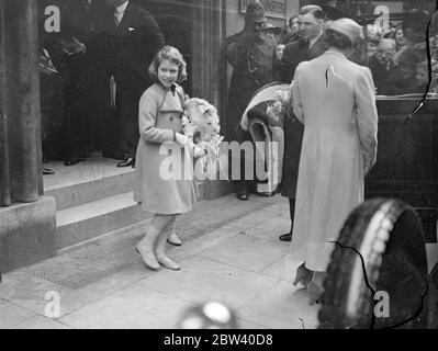 La principessa Elisabetta ritornò l'onda di un astante quando lasciò la Sala Centrale, Westminster, con la Regina e la Principessa Margaret Rose dopo aver partecipato al concerto di incoronazione per bambini. La principessa Elisabetta ritornò l'ondata di persone raccolte fuori dalla Sala Centrale Ashley partì con la Regina e la Principessa Margaret. 6 aprile 1937 Foto Stock