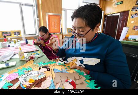 (200529) -- ALXA, 29 maggio 2020 (Xinhua) -- UN pastore fa il thangka ricamato dei capelli del cavallo in bandiera sinistra di Alxa, regione Autonoma interna della Mongolia della Cina del nord, 29 maggio 2020. Taogerile, 77 anni, è il principale ereditatore di thangka ricamata di capelli di cavallo nella regione autonoma della Mongolia interna. Ha detto che ha ereditato la lavorazione dal nonno e dalla madre. Preoccupato per la cultura morente, Taogerile è stato dedicato all'eredità dell'arte tradizionale. Il ricamo complicato è stato designato come un programma di riduzione della povertà in Alxa Left Banner. Finora, questa lavorazione ha directl Foto Stock