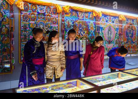 (200529) -- ALXA, 29 maggio 2020 (Xinhua) -- Taogerile (L) introduce il thangka ricamato dai capelli di cavallo ai pastori al museo per il thangka dei capelli di cavallo in Alxa Banner sinistro, regione Autonoma della Mongolia interna della Cina del nord, 29 maggio 2020. Taogerile, 77 anni, è il principale ereditatore di thangka ricamata di capelli di cavallo nella regione autonoma della Mongolia interna. Ha detto che ha ereditato la lavorazione dal nonno e dalla madre. Preoccupato per la cultura morente, Taogerile è stato dedicato all'eredità dell'arte tradizionale. Il ricamo complicato è stato designato come un programma di riduzione della povertà Foto Stock