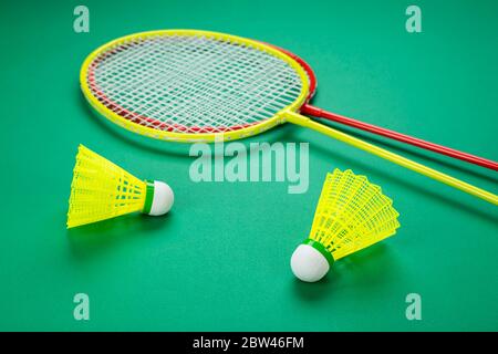 due racchette di badminton con un shuttleock giacciono su uno sfondo verde Foto Stock