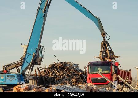 caricamento di rottami metallici e detriti su un carrello Foto Stock