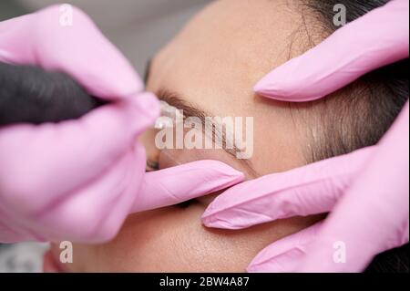 Primo piano femmina permanente eyeliner tatuaggi valorizzazione colorazione in spa Foto Stock
