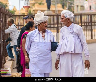 Somnath, Gujarat, India - Dicembre 2018: Un ritratto di strada candido di due vecchi uomini vestiti in abito bianco, tradizionale che hanno una conversazione nel PIL Foto Stock