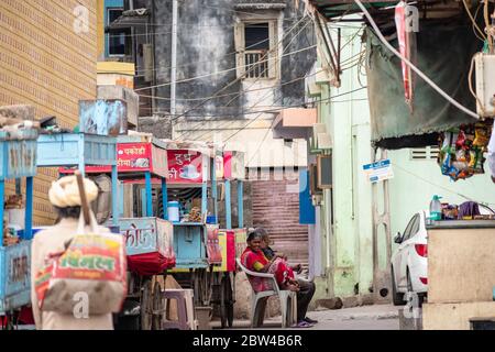 Somnath, Gujarat, India - Dicembre 2018: Donne indiane vestite in saris seduti in una strada tranquilla accanto alle bancarelle di cibo di strada. Foto Stock