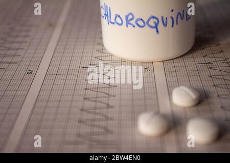 Effetti avversi sul cuore da parte di idrossiclorochina o clorochina. Pillole su un elettrocardiogramma con aritmie cardiache. Contenitore bianco con 'idro Foto Stock