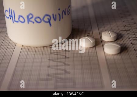 Effetti avversi sul cuore da parte di idrossiclorochina o clorochina. Pillole su un elettrocardiogramma con aritmie cardiache. Contenitore bianco con 'idro Foto Stock