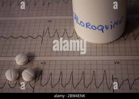 Effetti avversi sul cuore da parte di idrossiclorochina o clorochina. Pillole su un elettrocardiogramma con aritmie cardiache. Contenitore bianco con 'idro Foto Stock