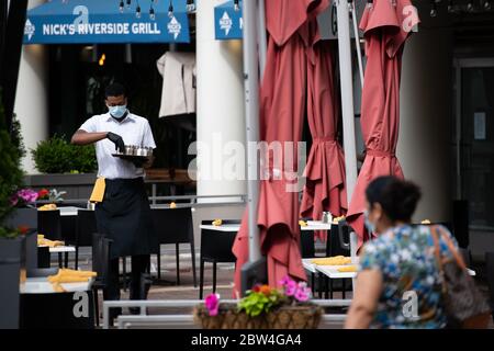 Un lavoratore prepara i tavoli per il servizio di pranzo presso un ristorante sul lungomare di Georgetown a Washington, D.C., il 29 maggio 2020, in mezzo alla pandemia di Coronavirus. Dopo aver mutato le metriche per la riapertura nelle ultime settimane, oggi il Distretto di Columbia ha iniziato la prima fase di riapertura economica consentendo ai ristoranti e ad altre aziende di operare in capacità limitata nonostante l'epidemia di COVID-19. (Graeme Sloan/Sipa USA) Foto Stock