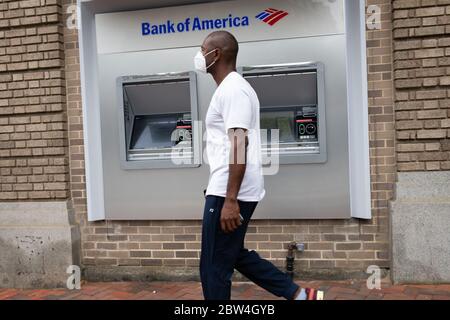 Washington, Stati Uniti. 29 maggio 2020. Un pedone mascherato cammina oltre una posizione Bank of America ATM a Washington, DC, il 29 maggio 2020 in mezzo alla pandemia di Coronavirus. Dopo aver mutato le metriche per la riapertura nelle ultime settimane, oggi il Distretto di Columbia ha iniziato la prima fase di riapertura economica consentendo ai ristoranti e ad altre aziende di operare in capacità limitata nonostante l'epidemia di COVID-19. (Graeme Sloan/Sipa USA) Credit: Sipa USA/Alamy Live News Foto Stock