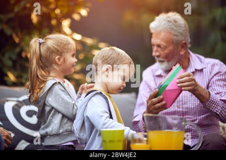 Buon nonno che si diverse e gioca con il loro nipote Foto Stock