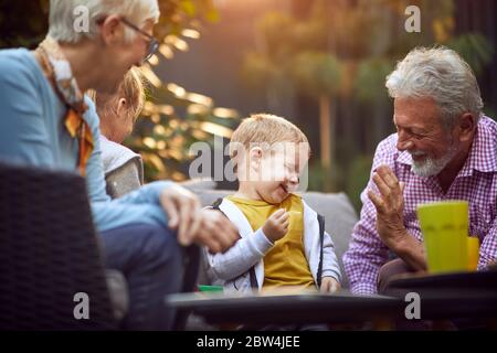 Nonno che si divergono e giocano con il loro nipote carino. Foto Stock