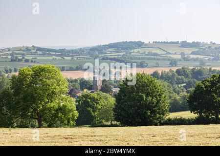 Badby, Northamptonshire, Regno Unito - 28 maggio 2020: La torre della Chiesa nel villaggio di Badby è circondata da alberi con la campagna ondulata alle spalle. Foto Stock