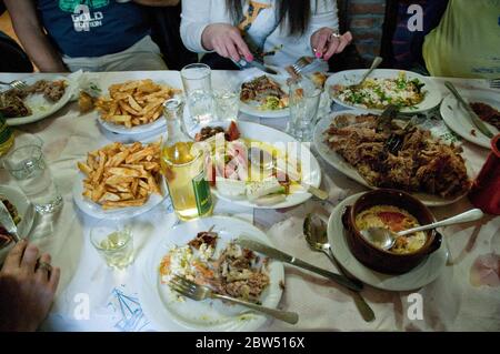 Un gruppo di amici greci cena in un ristorante locale del villaggio nella città di Profitis Ilias sull'isola di SAMOTHRAKI, Tracia, Grecia. Foto Stock