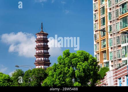 Chigang Pagoda che sorge sopra gli alberi contro un cielo blu vicino a un edificio di appartamenti in Guangzhou Cina, provincia di Guangdong. Foto Stock