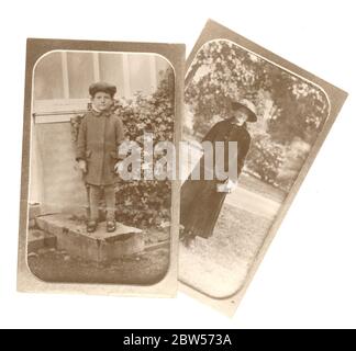 Copia di una foto edoardiana dei primi anni del '900 ripresa da un album fotografico, raffigurante una donna con un lungo cappotto e un ragazzino con un cappuccio, in piedi all'aperto, la foto originale è circa 1910, Regno Unito Foto Stock