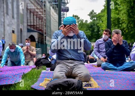 Pregare con maschere mediche fuori della Moschea Blu. Il primo venerdì pregate, namaz dopo la chiusura a Istanbul. I musulmani pregano insieme per la guarigione Foto Stock