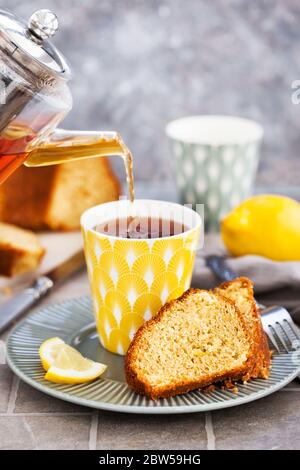 Fette di torta al limone e tazza di tè nero caldo Foto Stock