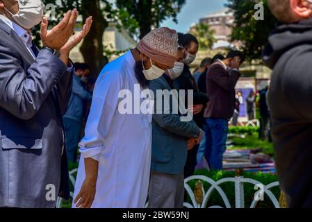 Pregare con maschere mediche fuori della Moschea Blu. Il primo venerdì pregate, namaz dopo la chiusura a Istanbul. I musulmani pregano insieme per la guarigione Foto Stock