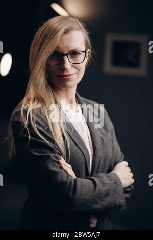 Donna sicura in abiti formali in piedi in ufficio Foto Stock