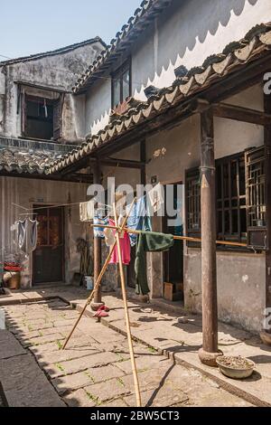 Tongli, Jiangsu, Cina - 3 maggio 2010: Rete di Hutong di passaggi pedonali stretti, case semplici, e piccole imprese. Vista sul cortile della casa con asciuga Foto Stock