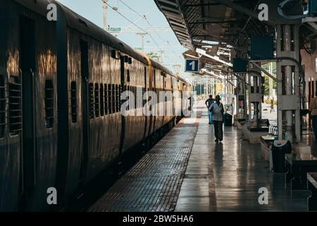 Le Ferrovie indiane trainano le carrozze ad una piattaforma relativamente vuota della stazione di Puducherry, in una mattina presto Foto Stock