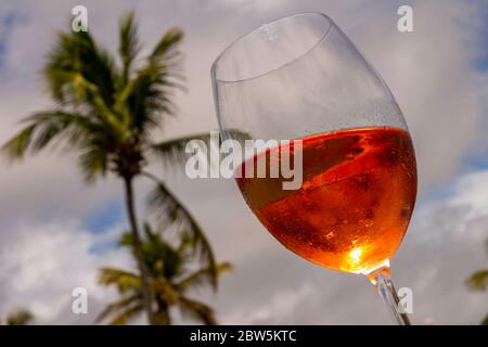 Bicchiere di cristallo con vino rosato in un atteggiamento toast. Concetto di alta classe. Bevanda alcolica morbida e rinfrescante a base di uva. Foto Stock