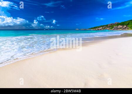 Spiaggia di sabbia bianca e mare turchese di Grand Anse con spazio per la copia nella sabbia. Carta da parati pacifica della spiaggia tropicale delle Seychelles, la Digue. Foto Stock